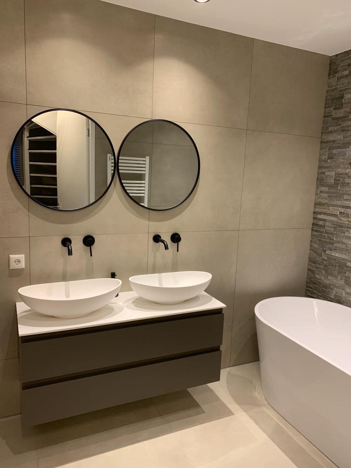 Moderne badkamer met dubbele waskom, vrijstaand bad en strakke afwerking